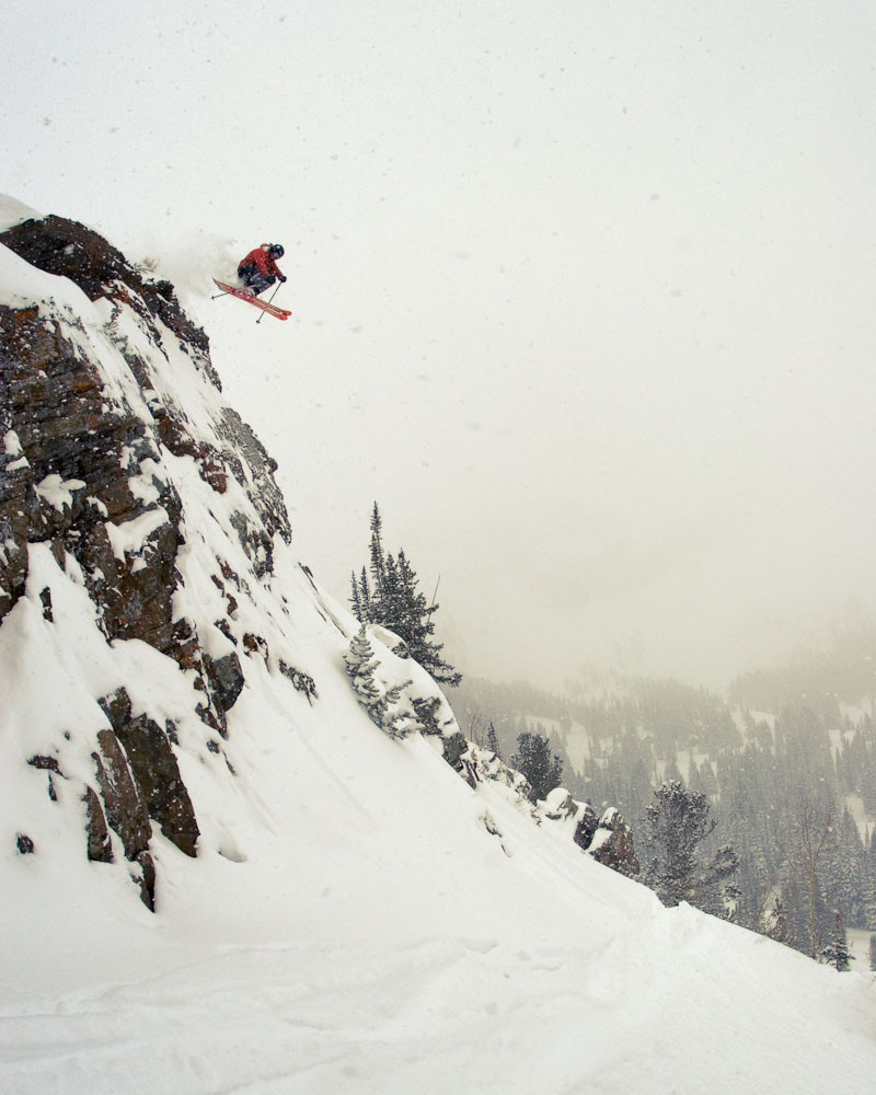 Male telemark skier jumping off a cliff at Alta Ski Area in Utah.