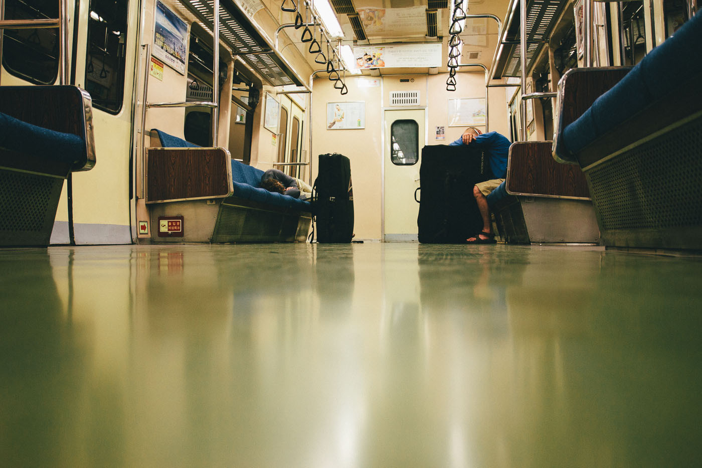 Dave McAllister and Paul Lammens sleep aboard a subway train in Seoul, South Korea